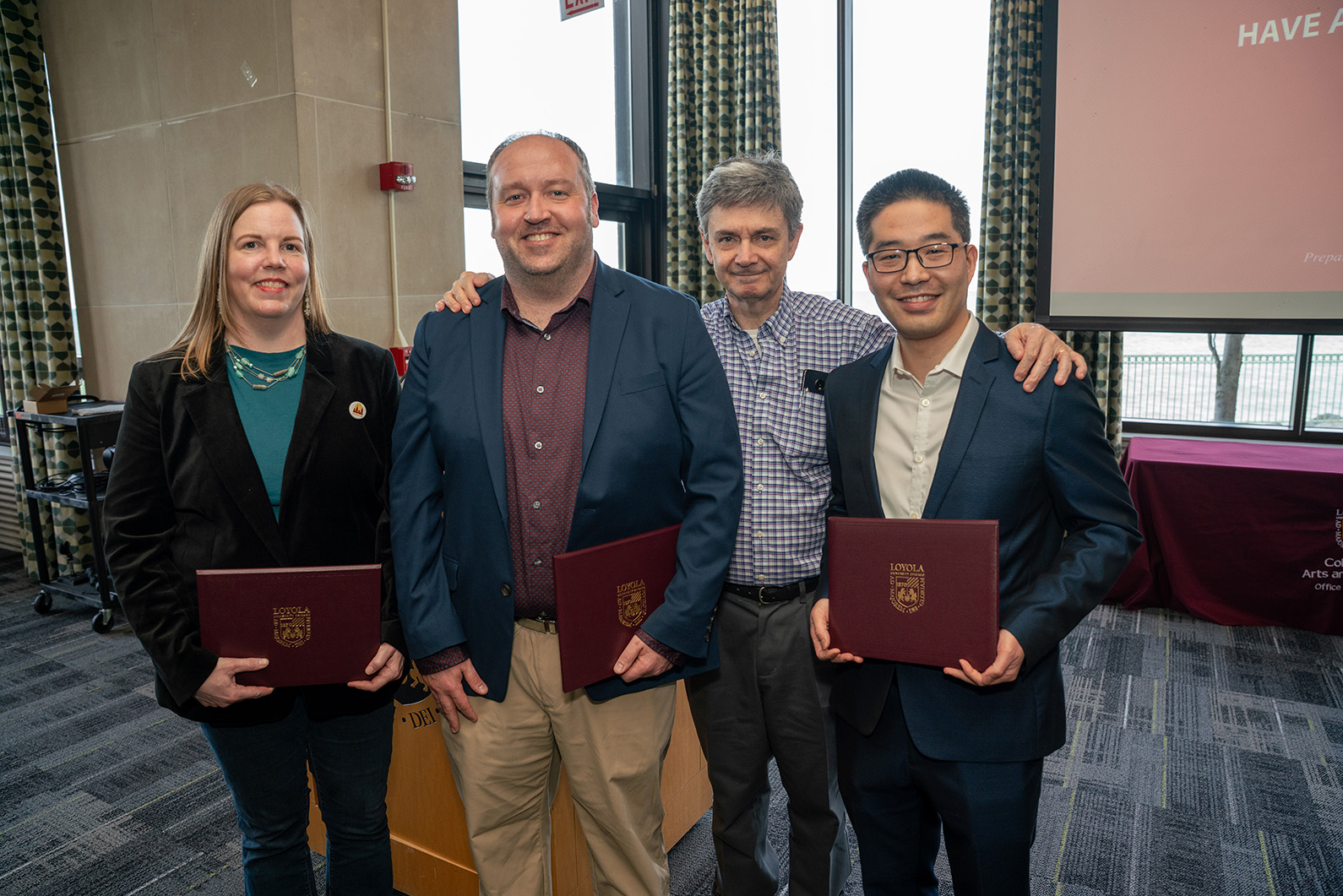four people pose with awards